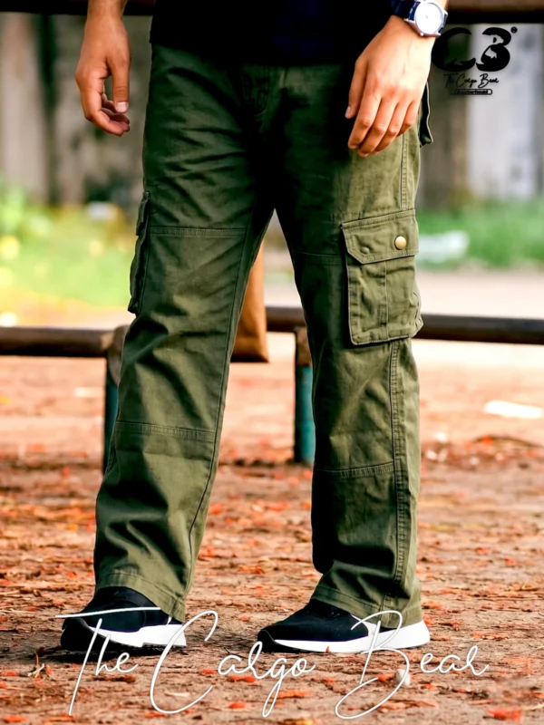 Olive green cargo pants with multiple flap pockets, relaxed fit, and black sneakers, worn outdoors on a natural ground setting.